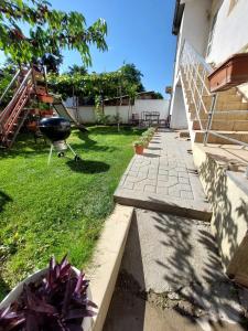 einen Hinterhof mit einem Grill und einem Rasenplatz in der Unterkunft Ceca & Dimi Apartments in Gevgelija