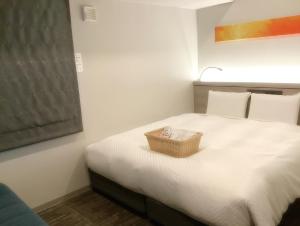 a bedroom with a bed with a basket on it at S-peria Inn Osaka Hommachi in Osaka