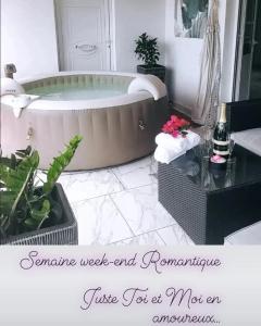 VillaBadlou "Lodge Ti-Kaco Vanille" في تروا ريفيير: حمام مع حوض استحمام وطاولة مع الزهور