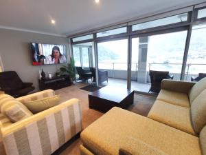 a living room with two couches and a tv at Oxleys 501 3 Bedroom Penthouse in Picton