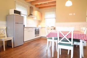 een keuken met een tafel, stoelen en een koelkast bij Hof Köhne - Haus an der Weide rechts in Schmallenberg