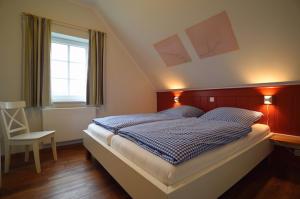 een slaapkamer met een bed, een stoel en een raam bij Hof Köhne - Haus an der Weide rechts in Schmallenberg