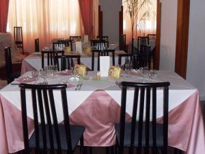 フスカルドにあるHotel Sudの白いテーブルクロスと椅子(ワイングラス付)