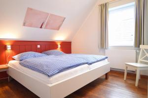een slaapkamer met een bed met een rood hoofdeinde bij Hof Köhne - Haus an der Weide links in Schmallenberg