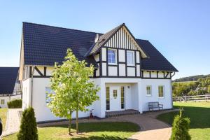 een groot wit huis met een zwart dak bij Hof Köhne - Haus an der Weide links in Schmallenberg