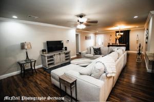 a living room with a white couch and a tv at “Home Away From Home” ( HAFH) in Baton Rouge