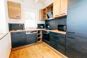 una cucina con armadi neri e pavimenti in legno di Hof Köhne - Landvergnügen rechts a Schmallenberg