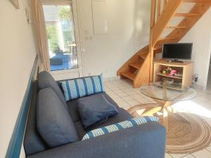 a living room with a blue couch and a glass table at Maison récente 6 pers., proche plage, jardin paisible, activités variées - FR-1-639-3 in Saint-Gildas-de-Rhuys