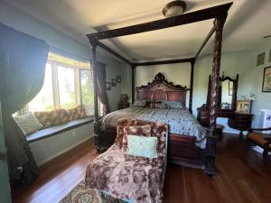 a bedroom with a large canopy bed with a chair at Universal Studios-Hollywood Hills guest suite with King bed in Los Angeles