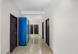 un couloir avec des murs et des portes bleus et blancs dans l'établissement OYO Hotel Grand Eden, à Kolkata