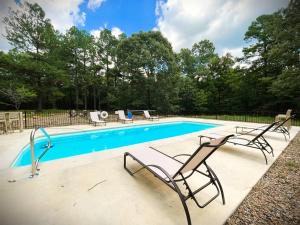 a swimming pool with two lawn chairs next to it at Soho Loft in Broken Bow