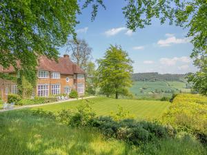 an exterior view of a house with a large lawn at Castle Hill House in Sidbury