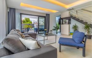 a living room with a couch and a blue chair at Nice Home In Pula With Kitchen in Pula