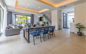 a dining room with a table and blue chairs at Nice Home In Pula With Kitchen in Pula