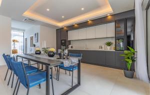 a kitchen and dining room with a table and blue chairs at Nice Home In Pula With Kitchen in Pula