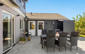 a patio with a table and chairs and a house at 3 Bedroom Stunning Home In Bagenkop in Bagenkop