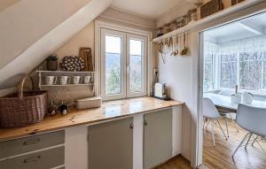 a kitchen with a counter and a table with chairs at 3 Bedroom Stunning Home In Vikebygd in Vikebygd