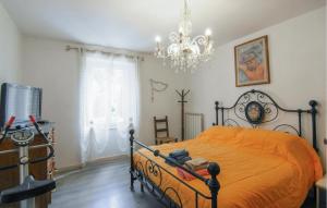 a bedroom with an orange bed and a chandelier at Awesome Home In Valpromaro With Wifi in Valpromaro