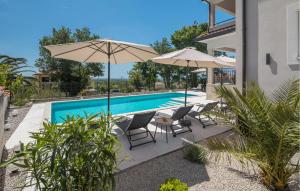 - une piscine avec des chaises et des parasols à côté d'une maison dans l'établissement Gorgeous Home In Rojci With Kitchen, à Kaštelir 44 autres photos