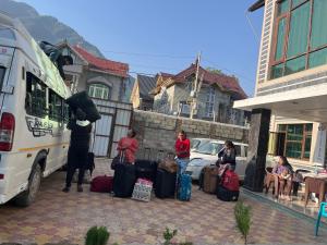 un grupo de personas de pie junto a un autobús con equipaje en The Light House en Srinagar