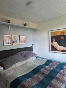 um quarto com uma cama e quadros na parede em Hyggelig ferielejlighed i Harresø em Give