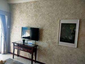 sala de estar con mesa y TV en la pared en To bedroom apartment sea, en Tanjung Bungah