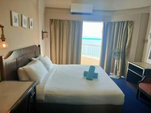 Una habitación de hotel con una cama con una cruz azul. en To bedroom apartment sea, en Tanjung Bungah 6 fotos más