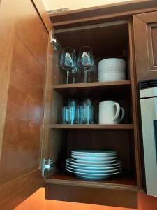 a cupboard filled with plates and cups and dishes at MGM Studio Suite with POOL VIEW Tower 1 in Las Vegas