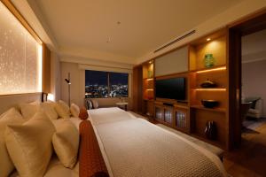 a living room with a couch and a television at Hotel Nikko Kanazawa in Kanazawa