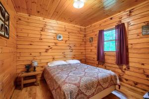 a bedroom with a bed in a log cabin at Blue Rose Cabins - Pine Ridge Cabin in Logan +4 photos