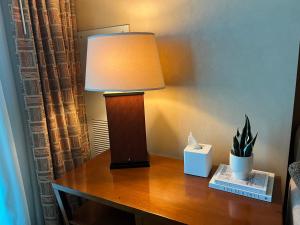 a lamp on a desk with a plant on it at MGM Studio Suite with POOL VIEW Tower 1 in Las Vegas