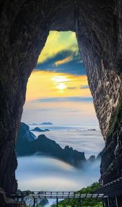 a window in a rock cliff with a view of a body of water at Zhangjiajie Jijiehao Inn in Zhangjiajie