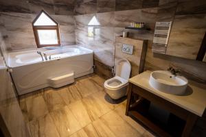 a bathroom with a tub and a toilet and a sink at Sea Golden Hotel in Darıca