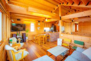 a living room with wooden walls and wooden floors at 「KIRAKU」Wood House稚内 in Wakkanai