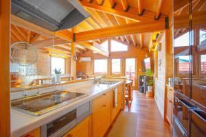 a large kitchen with wooden ceilings and wooden floors at 「KIRAKU」Wood House稚内 in Wakkanai