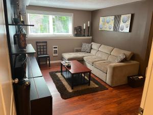 a living room with a couch and a table at Cozy and modern 3 bedroom in central location! in Victoria