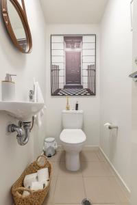 a bathroom with a toilet and a sink and a mirror at VAQUAY Scandi Boho In Docklands in Melbourne