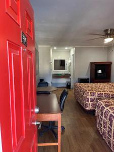 a hotel room with two beds and a red door at Hill Country Inn in Johnson City