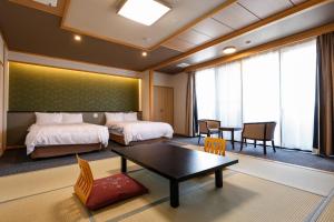 a hotel room with two beds and a table at シーサイド佐竹 in Kyotango