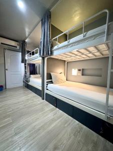 2 Etagenbetten in einem Zimmer mit Holzböden in der Unterkunft The August Hostel in Chiang Mai