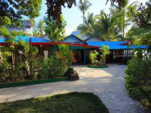 ein Gebäude mit einem blauen Dach mit Bäumen davor in der Unterkunft Hadefe Resort in El Nido