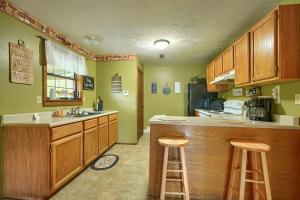 ローガンにあるBlue Rose Cabins - Rosewood Cabinのキッチン(木製キャビネット、バースツール付)