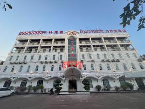 un bâtiment blanc avec un panneau à l'avant dans l'établissement CHALEUNXAY HOTEL, à Vientiane