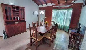 a dining room with a table and chairs and a television at Magnolia azul in Federación