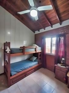 フェデラシオンにあるMagnolia azulの二段ベッド2台、シーリングファンが備わる客室です。