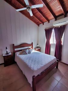 Schlafzimmer mit einem Bett und einem Deckenventilator in der Unterkunft Magnolia azul in Federación