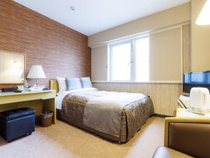 a hotel room with a bed and a television at Tabist Hokkaido Daiichi Hotel Sapporo in Sapporo
