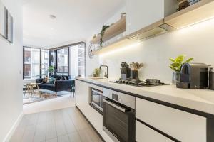 a kitchen with white counters and a stove top oven at VAQUAY Soho In Docklands in Melbourne
