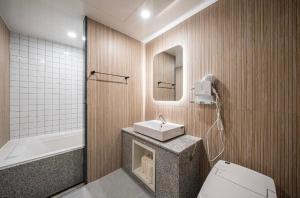 a bathroom with a sink and a toilet and a mirror at Brown Dot Hotel Andong Ok-dong in Andong