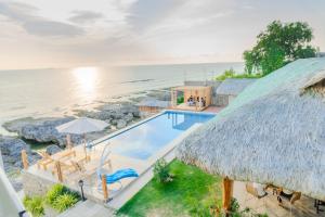an aerial view of a resort with a swimming pool and the ocean at Sofia - Summer Coastal Suites in Bacnotan